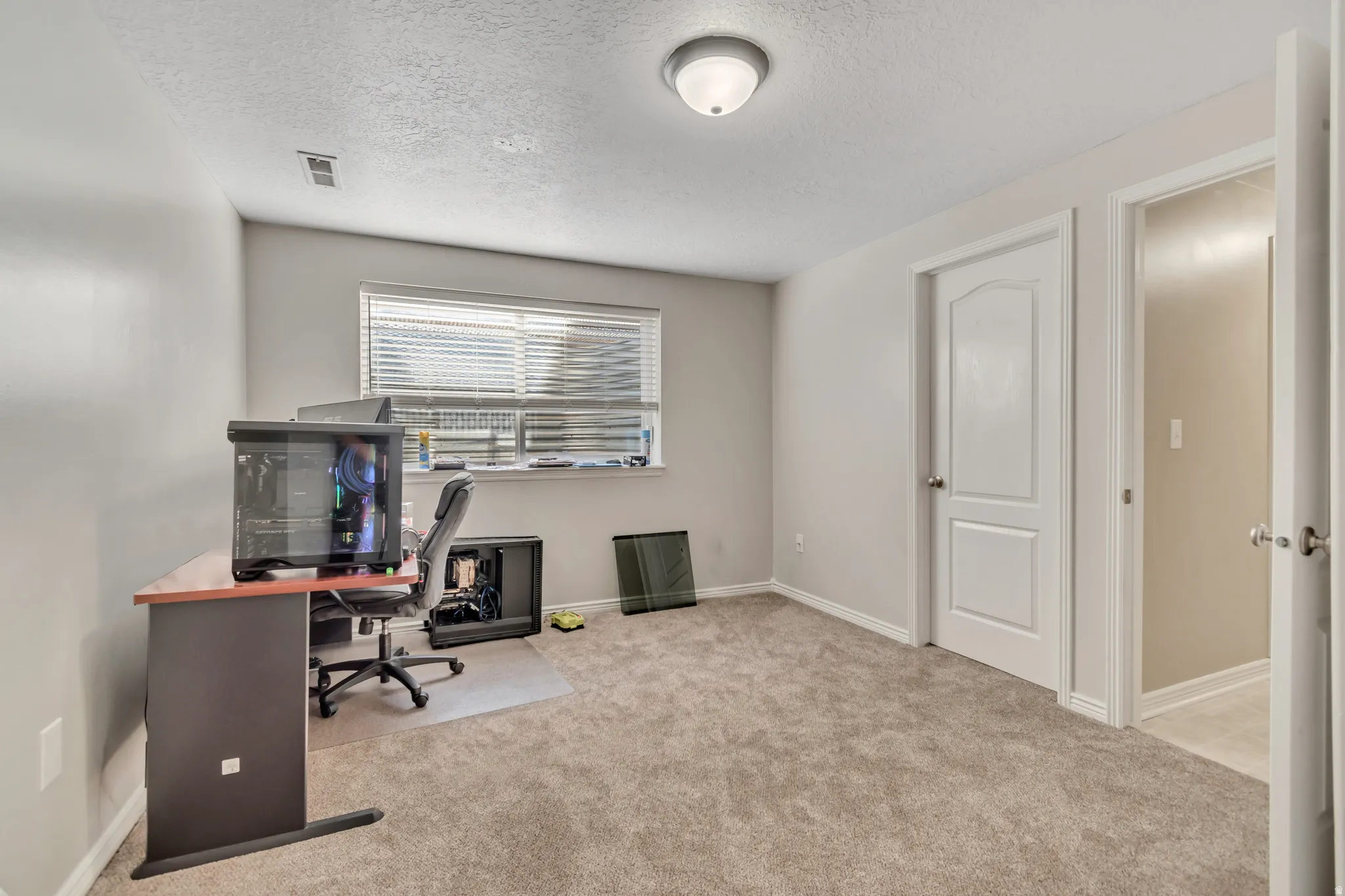 Carpeted room featuring light gray wall paint, a window with horizontal blinds, and a semi-flush mount ceiling light fixture