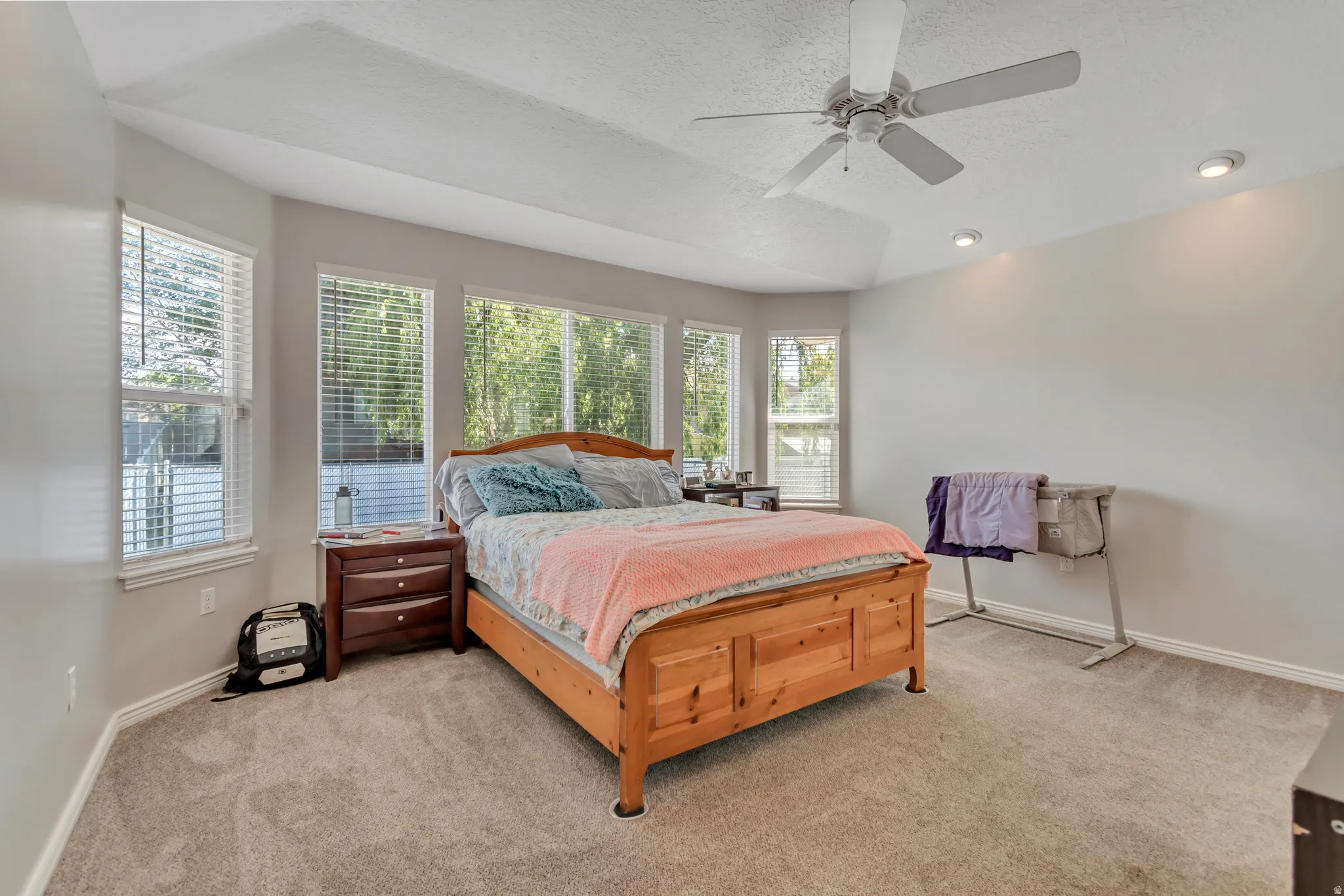 Carpeted bedroom with a vaulted ceiling and recessed lighting