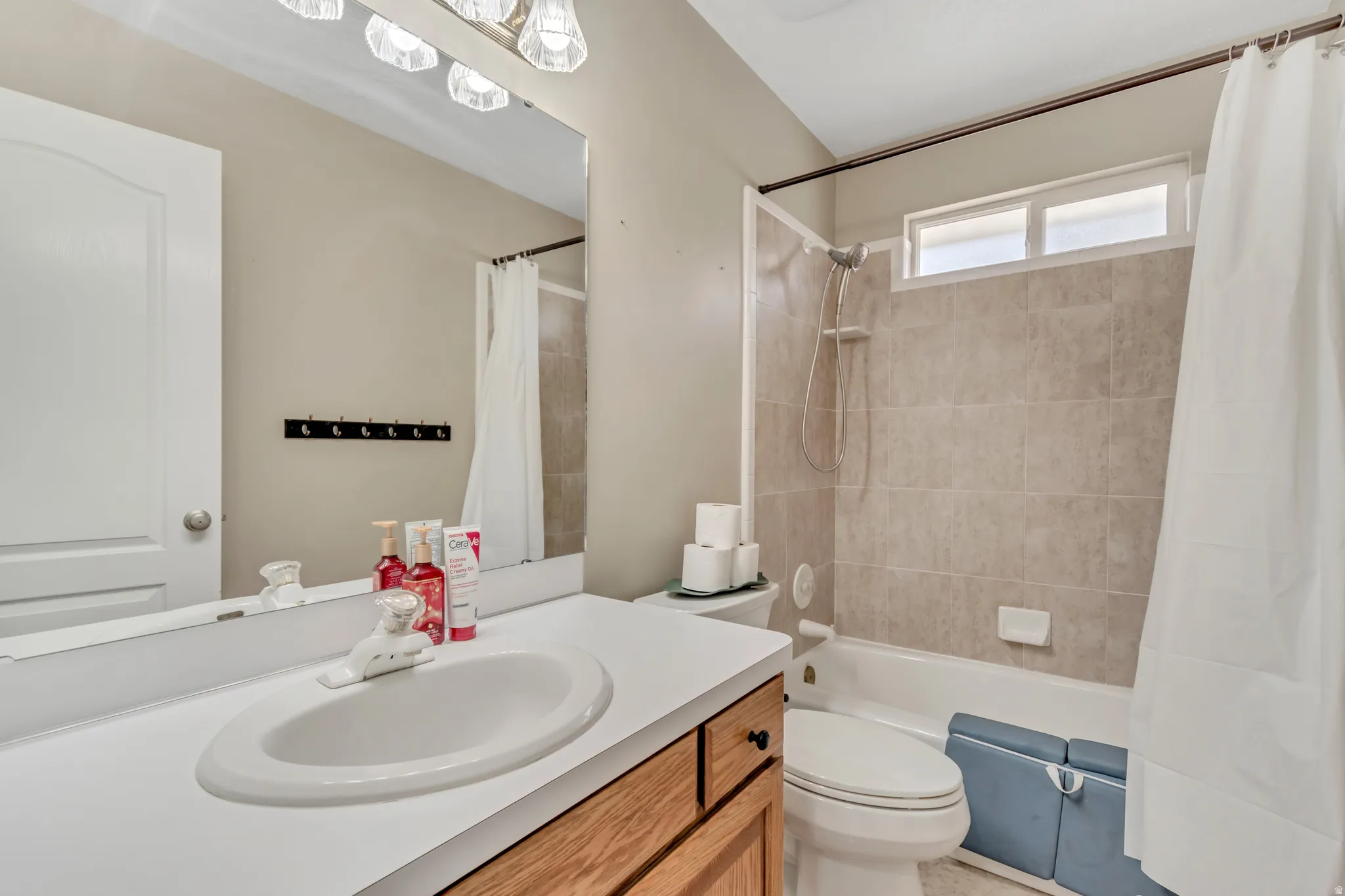 Bathroom featuring a wood-finish vanity with an integrated sink and a large mirror