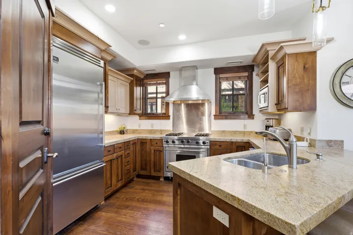 Gourmet kitchen featuring a stainless steel Viking refrigerator, professional-grade range, built-in microwave, and granite countertops