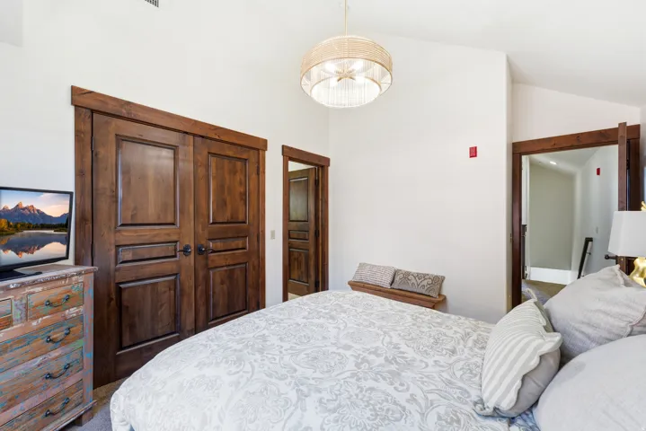 Room featuring vaulted ceilings and a statement woven pendant light fixture