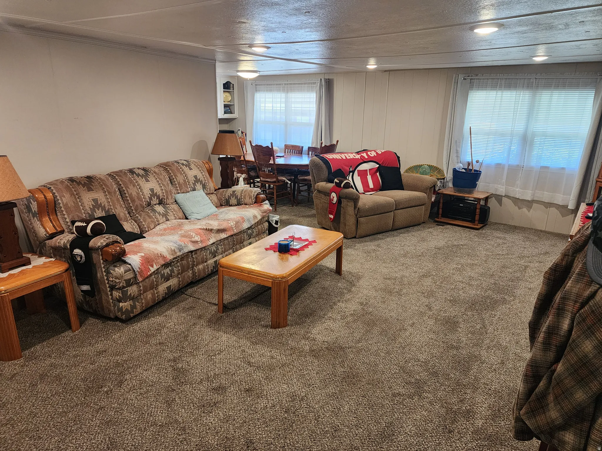 Living area featuring broadloom carpeting and multiple windows for natural light