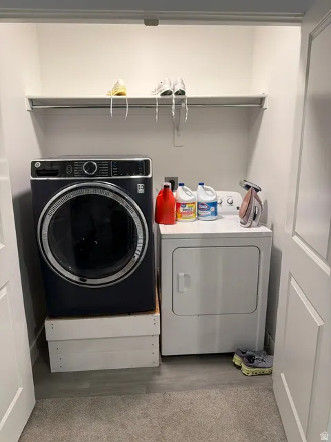 Dedicated laundry closet with white walls and a white wire shelf