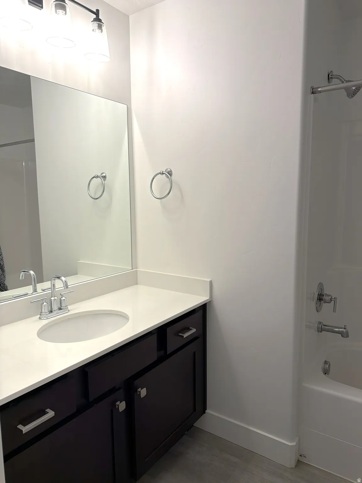 Vanity featuring a white countertop with an integrated sink and chrome faucet