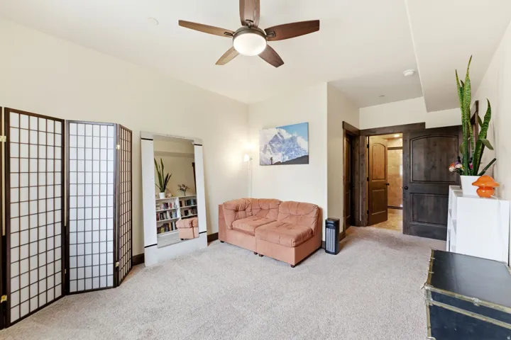 Spacious room with plush carpeting and a ceiling fan