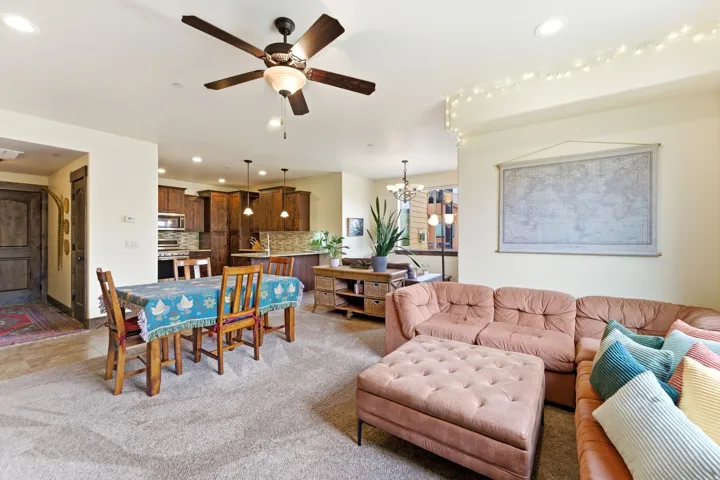 Open-concept living area with carpet flooring and ceiling fan