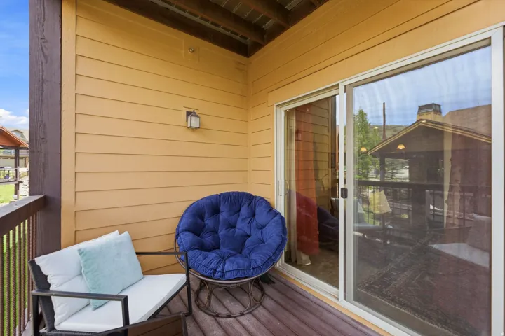 Private exterior balcony featuring a sliding glass door, horizontal siding, and a ceiling-mounted light fixture