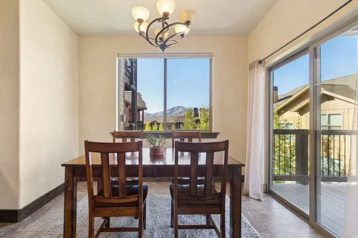 Dining area featuring a window with mountain scenery, a five-light chandelier, and light-toned wall paint