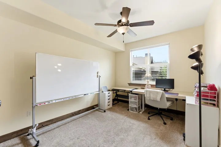 Carpeted room with a ceiling fan light fixture