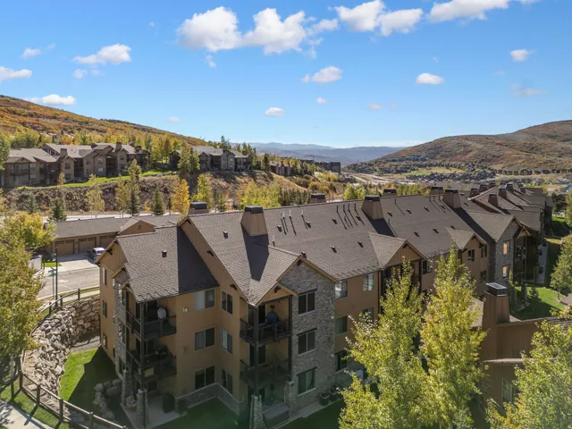 Multi-story residential buildings featuring balconies, stone facades, and sloped roofs