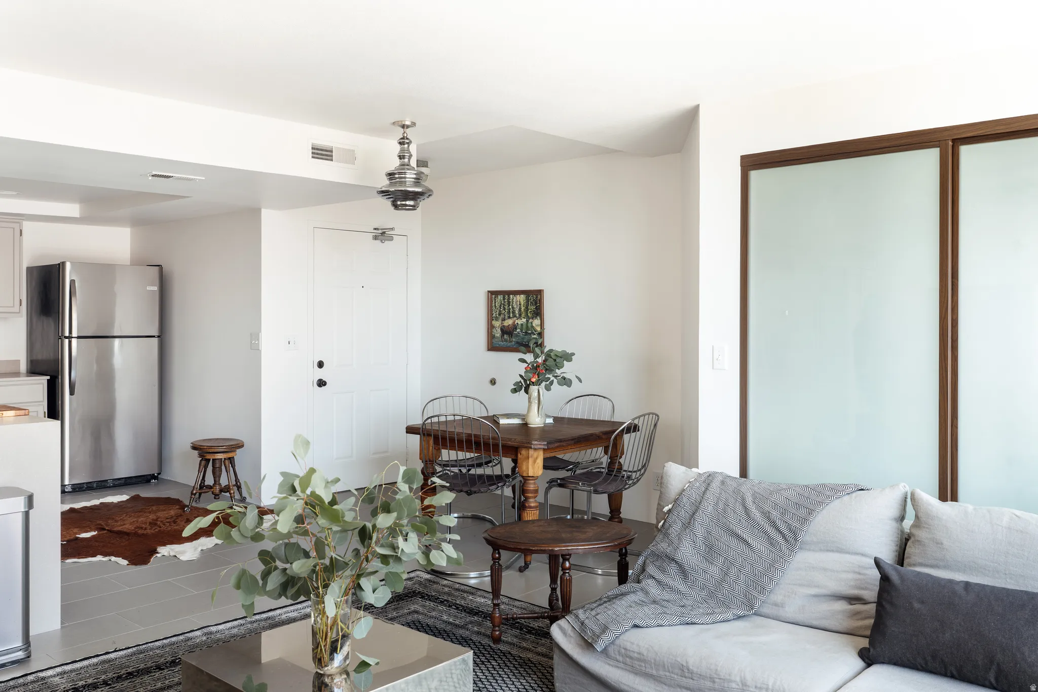 Open-concept living space with light gray tile flooring and white walls