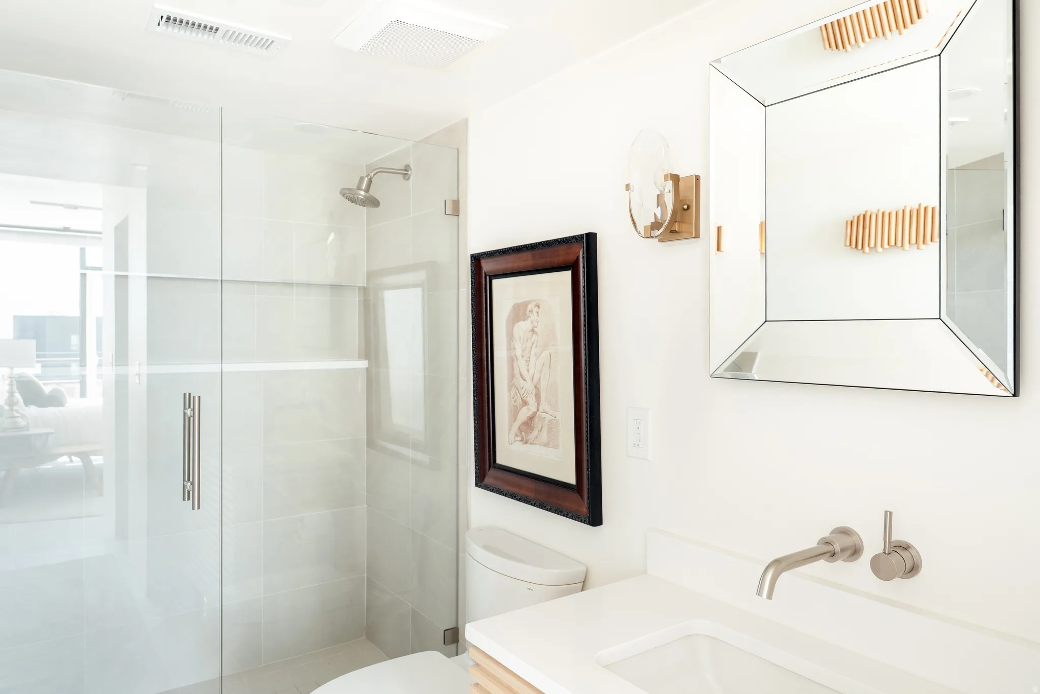 Contemporary bathroom featuring a glass-enclosed shower with tile surround, a wall-mounted faucet, and a vessel sink set into a white countertop