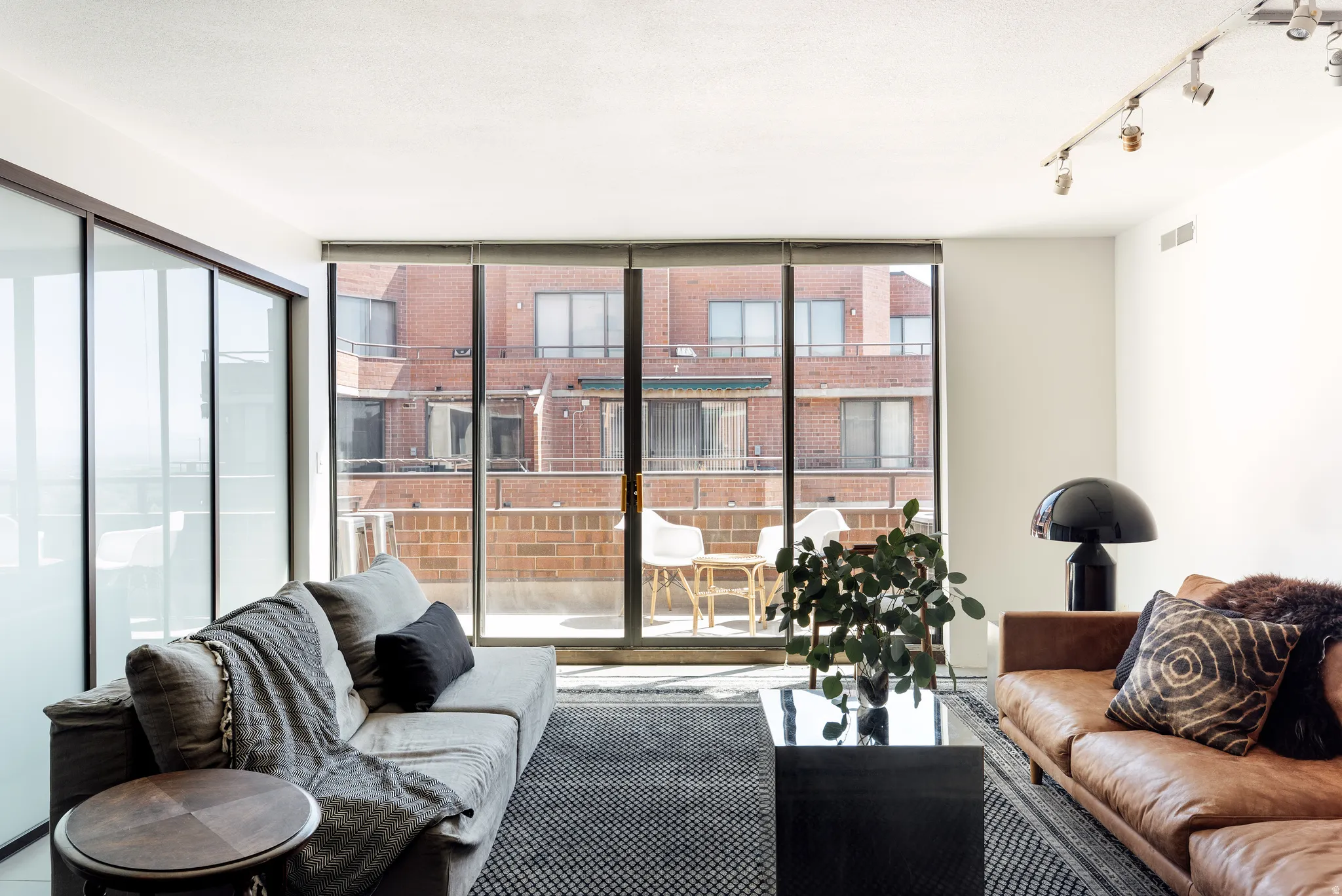 Living area featuring a full wall of glass doors opening to a private balcony