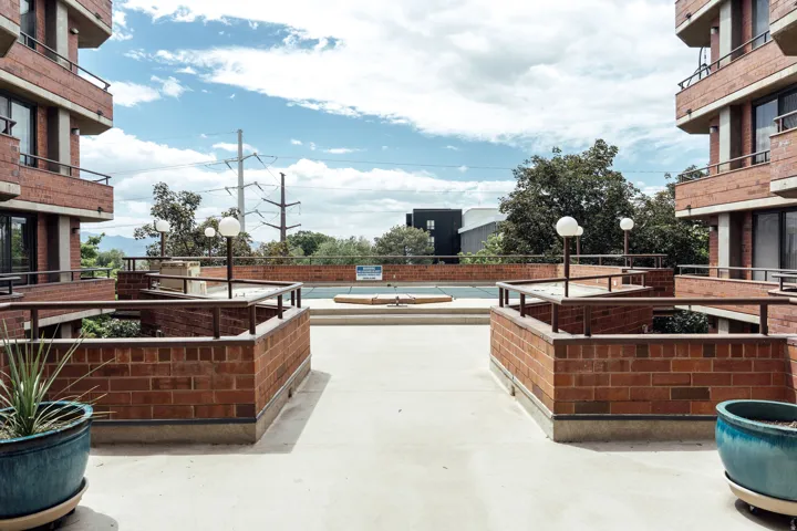 Exterior deck area featuring brick half-walls, metal railings, and integrated sphere light fixtures