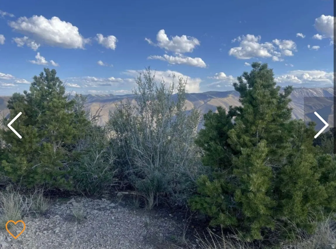 Expansive mountain scenery with a clear blue sky and scattered clouds