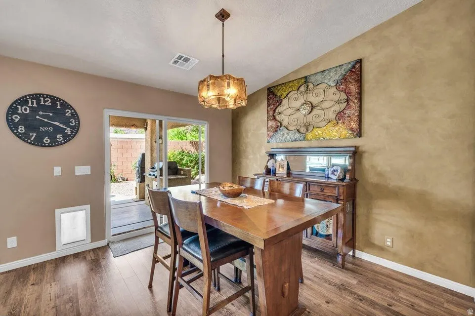 Dining area featuring wood-finish flooring and a contemporary light fixture