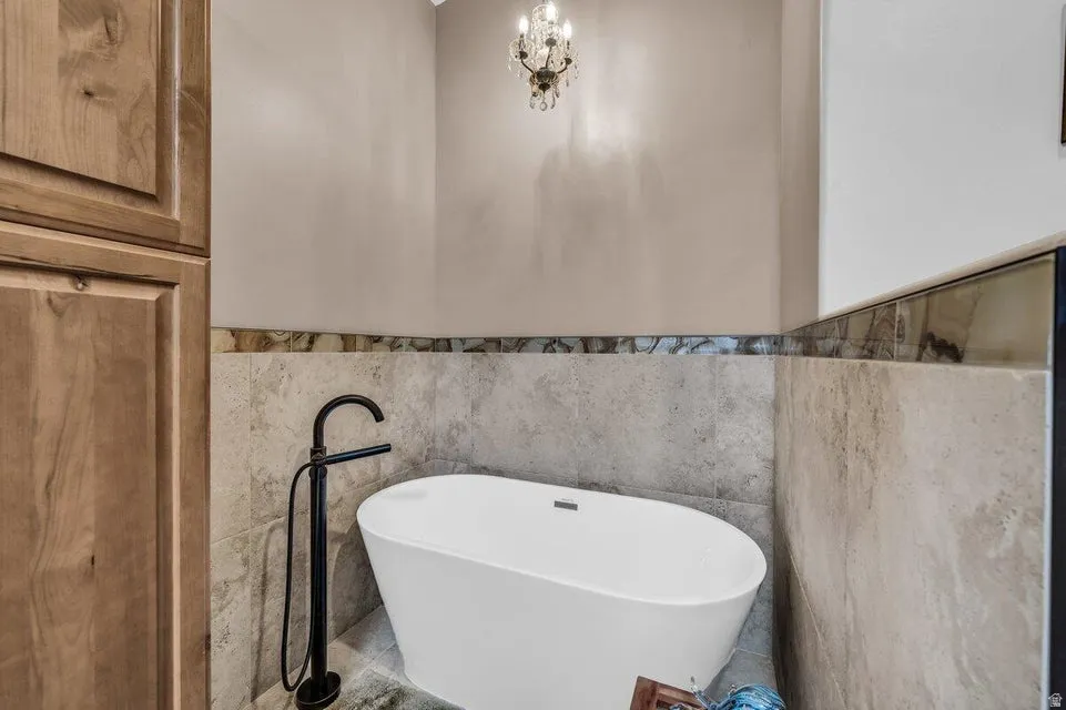 Freestanding soaking tub with a floor-mounted matte black faucet