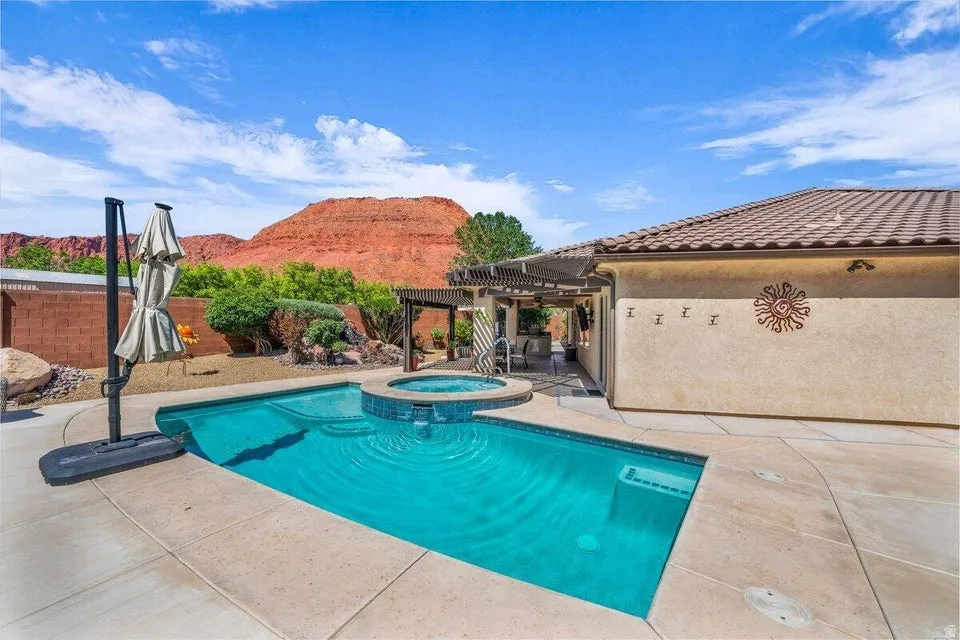 Backyard oasis featuring a sparkling blue swimming pool with an integrated spa