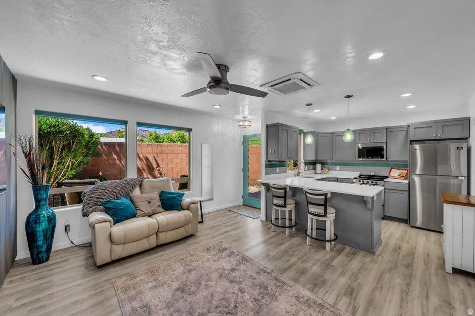 Open-concept living space featuring wood-finish flooring, recessed lighting, and a ceiling fan