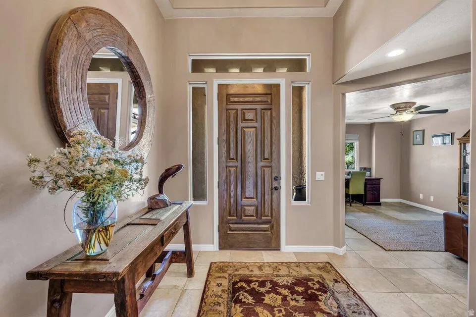 Entryway featuring a paneled wood door with sidelights and transom window