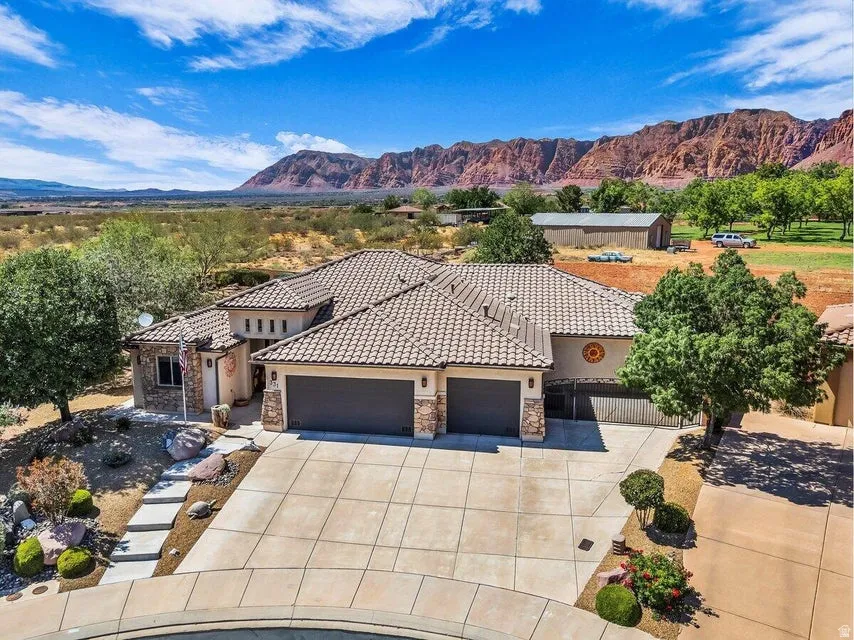 Southwestern-style residence featuring a tile roof, a stone and stucco exterior, and a concrete driveway