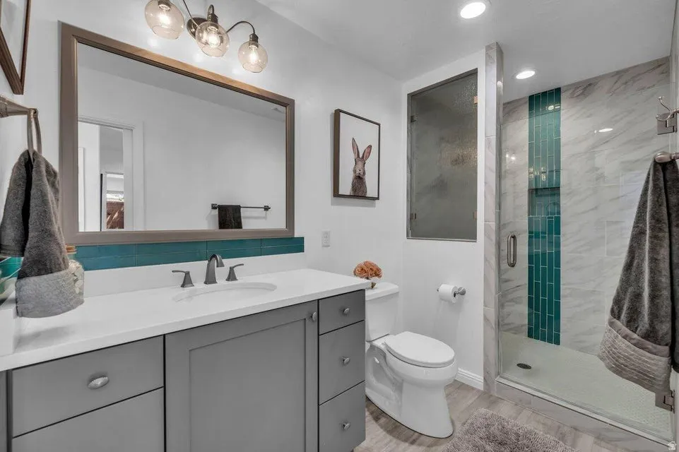 Contemporary vanity with a rectangular undermount sink, a light-toned countertop, and dark-toned cabinetry