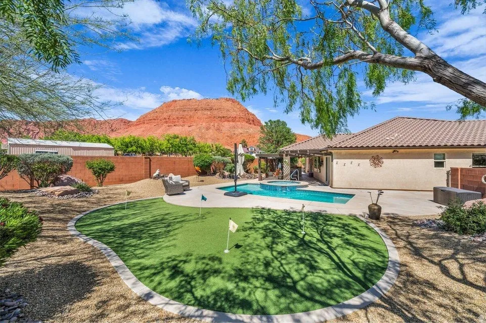 Expansive backyard featuring a built-in putting green, swimming pool, and spa