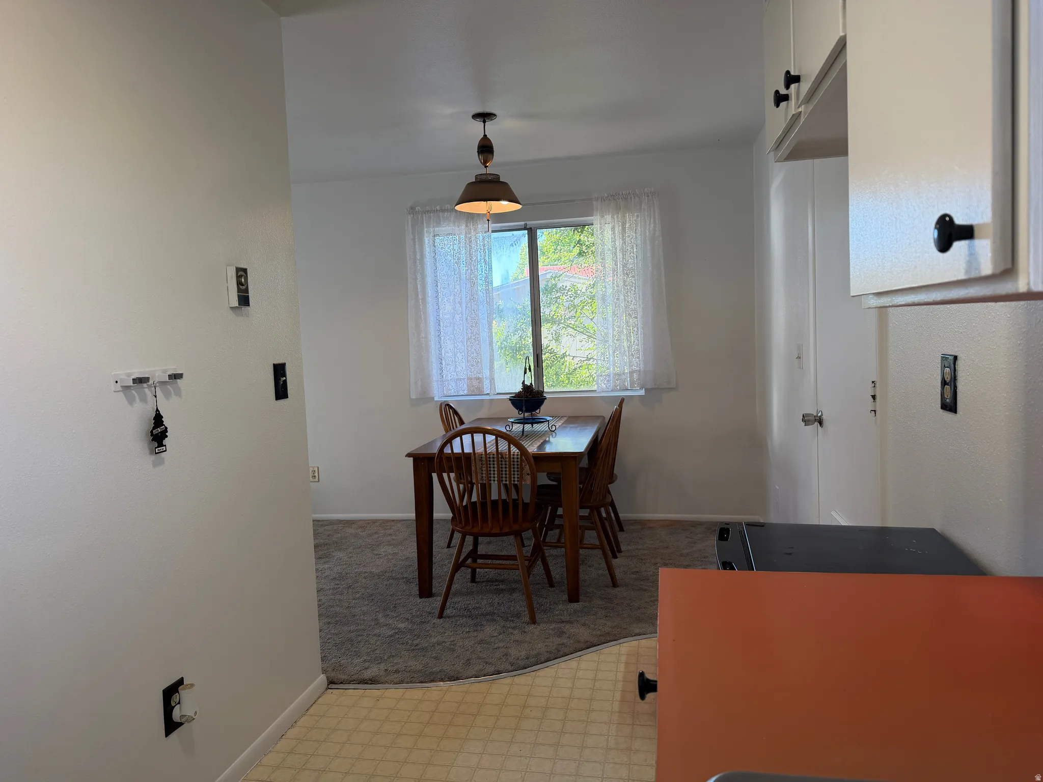 Dining area featuring a window with natural light, overhead pendant lighting, and carpet flooring