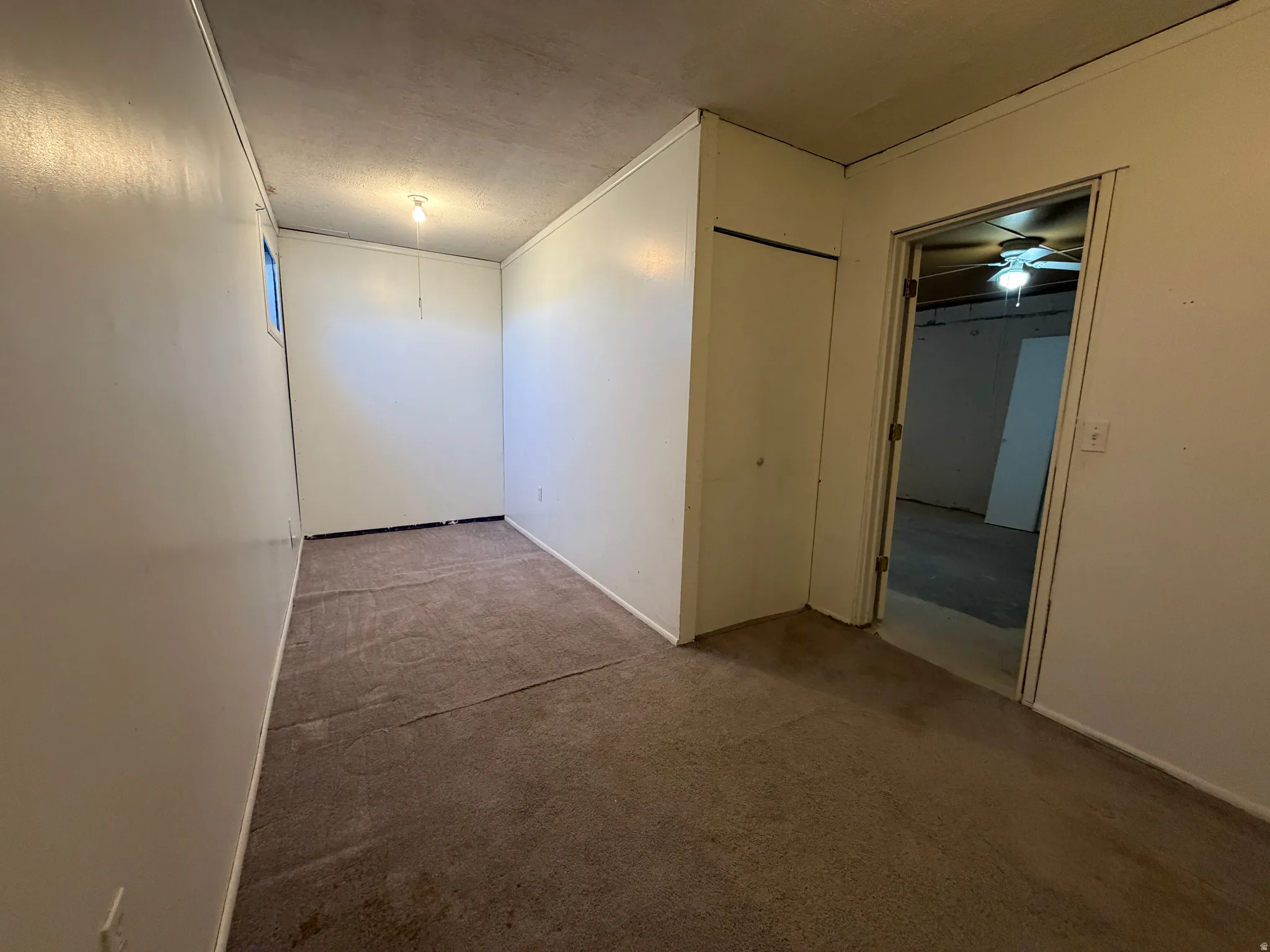 Carpeted interior space with a window, white paneled walls, and a recessed ceiling light