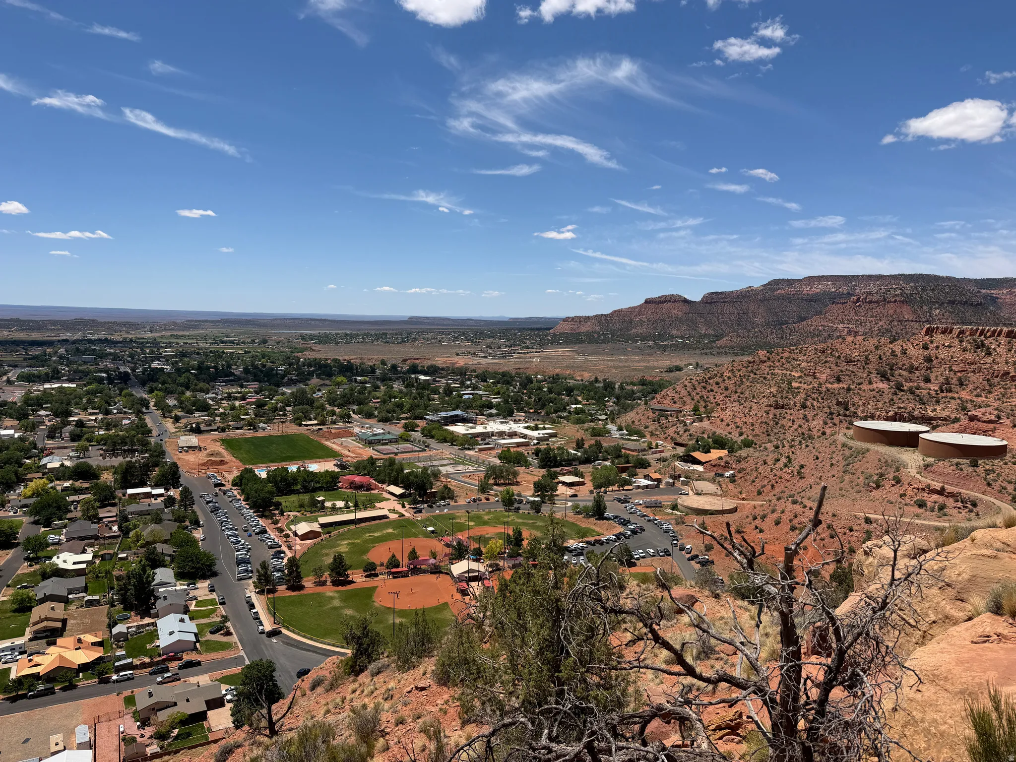 Expansive high-elevation panorama overlooking a community with residential areas and recreational fields