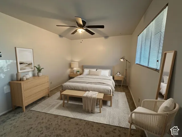 Bedroom featuring a ceiling fan with integrated lighting, a broad window with horizontal blinds, and neutral-toned wall finishes