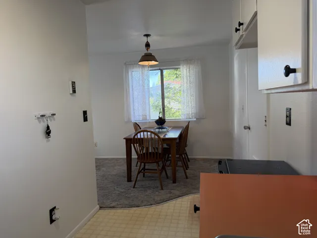Dining area featuring a window with natural light, overhead pendant lighting, and carpet flooring