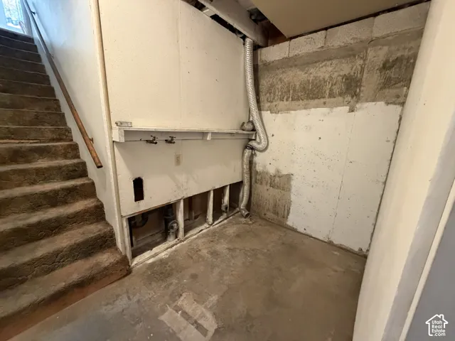 Utility area featuring exposed plumbing and concrete flooring