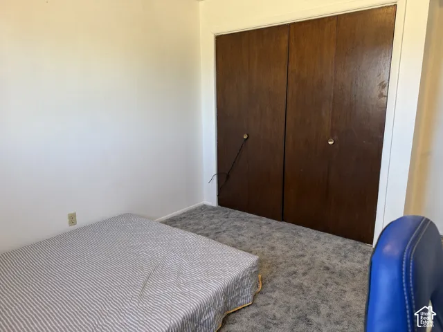 Bedroom featuring white walls and grey patterned carpeting