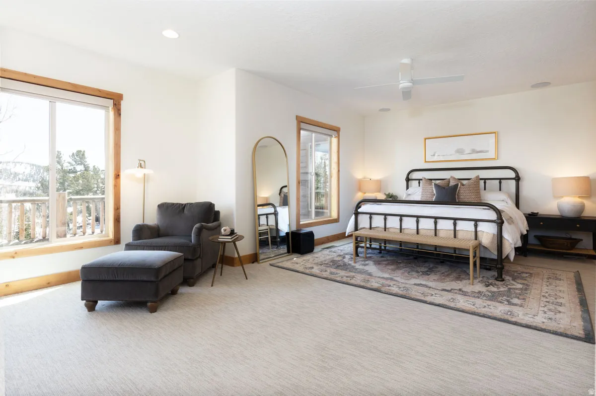 Bright bedroom featuring natural light, wood-trimmed windows, recessed lighting, a ceiling fan, and light-toned carpeting