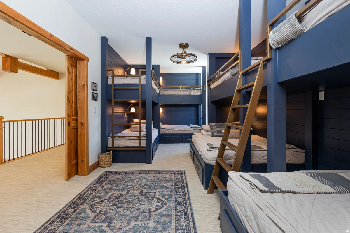 Custom-built bunk room featuring integrated storage, individual reading lights, and a central decorative ceiling fixture