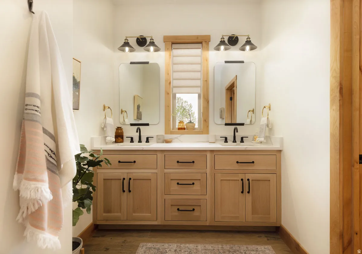 Dual vanity with wood-finish cabinetry, white countertop, and integrated sinks