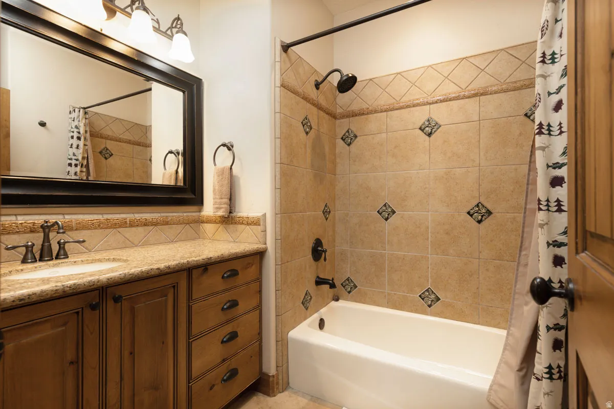 Bathroom featuring a built-in vanity with wood cabinetry, a granite countertop, and an integrated sink