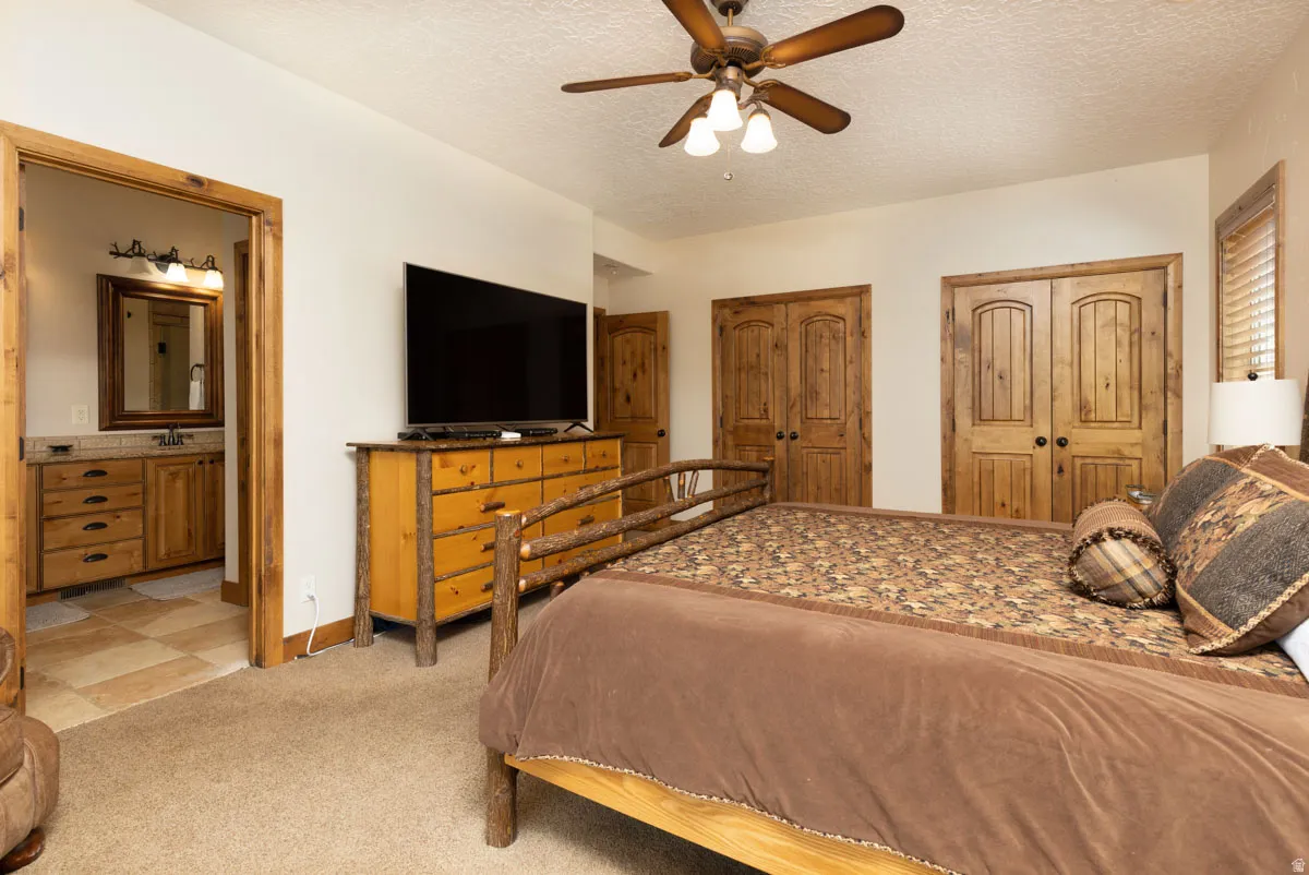 Spacious room featuring carpeting, a ceiling fan, and solid wood double doors