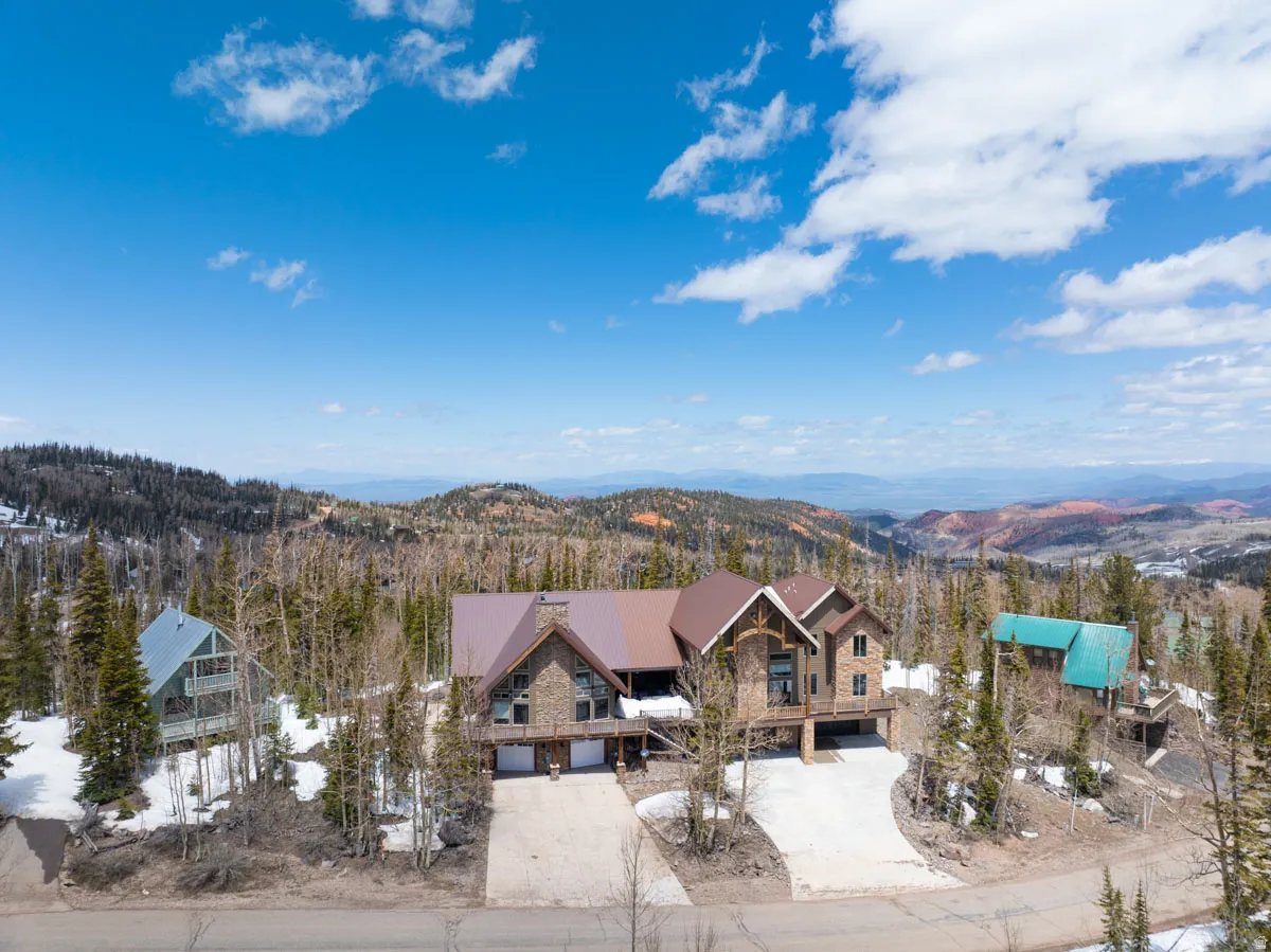 Stone and wood-clad mountain home with a rich brown roof