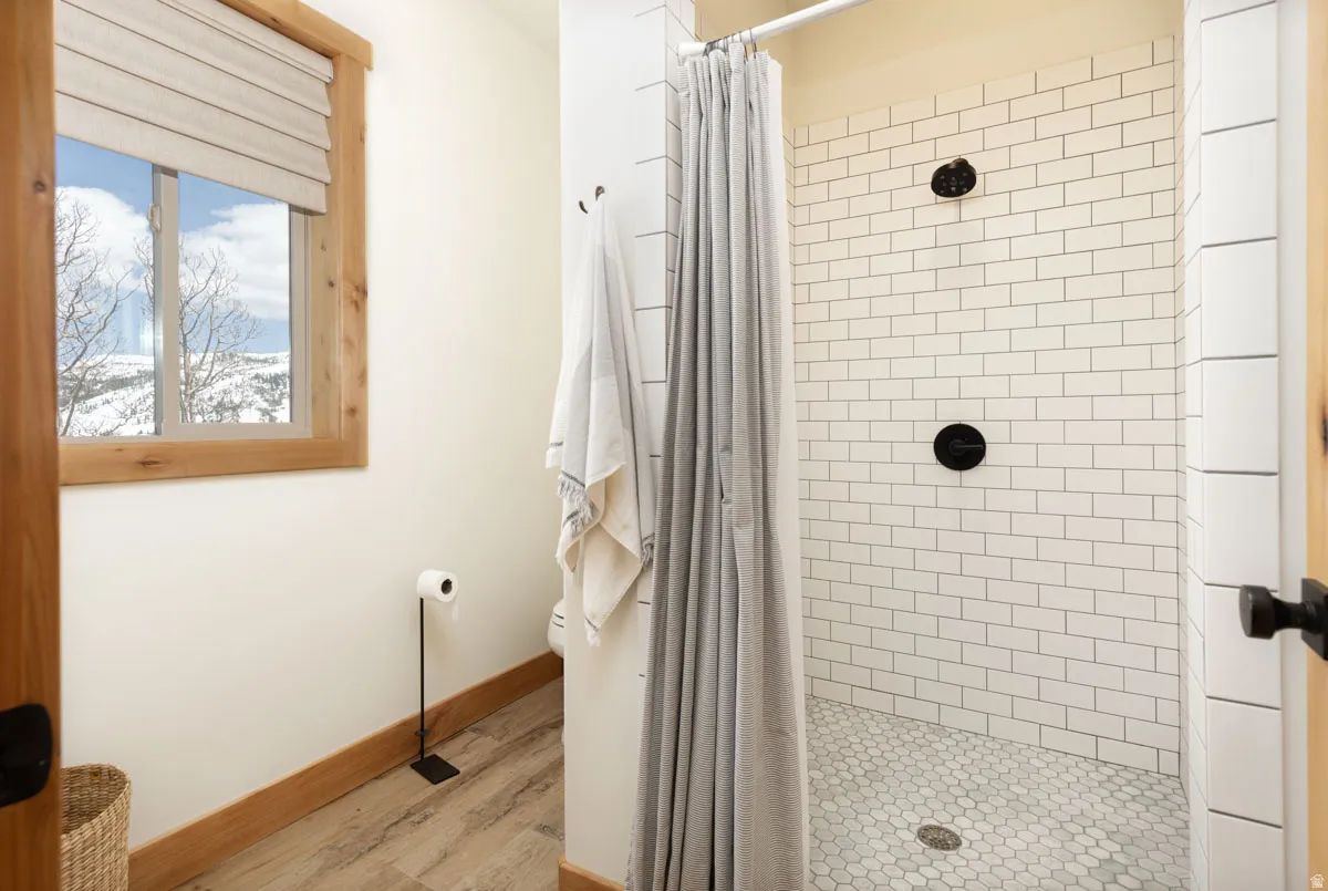 Shower featuring white subway tile walls, a hexagonal tile floor, and matte black fixtures