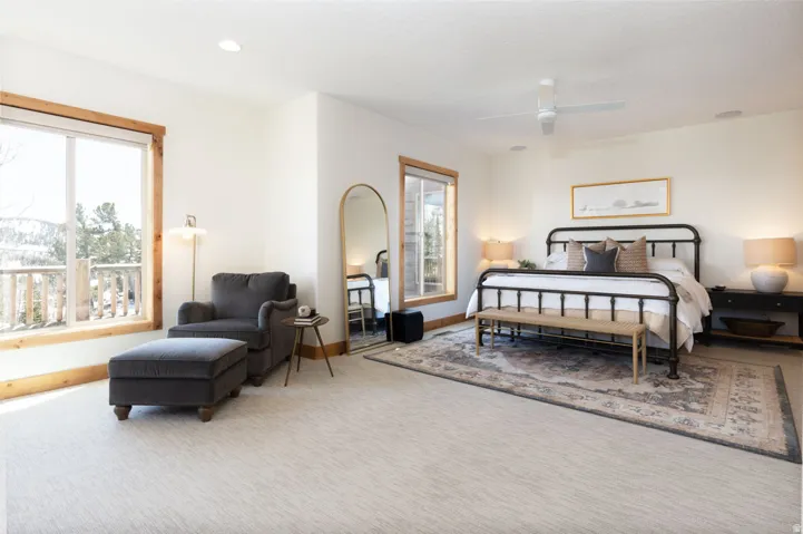 Bright bedroom featuring natural light, wood-trimmed windows, recessed lighting, a ceiling fan, and light-toned carpeting