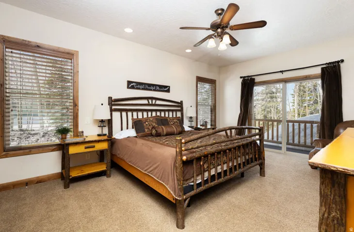 Spacious bedroom featuring light beige walls and textured carpeting