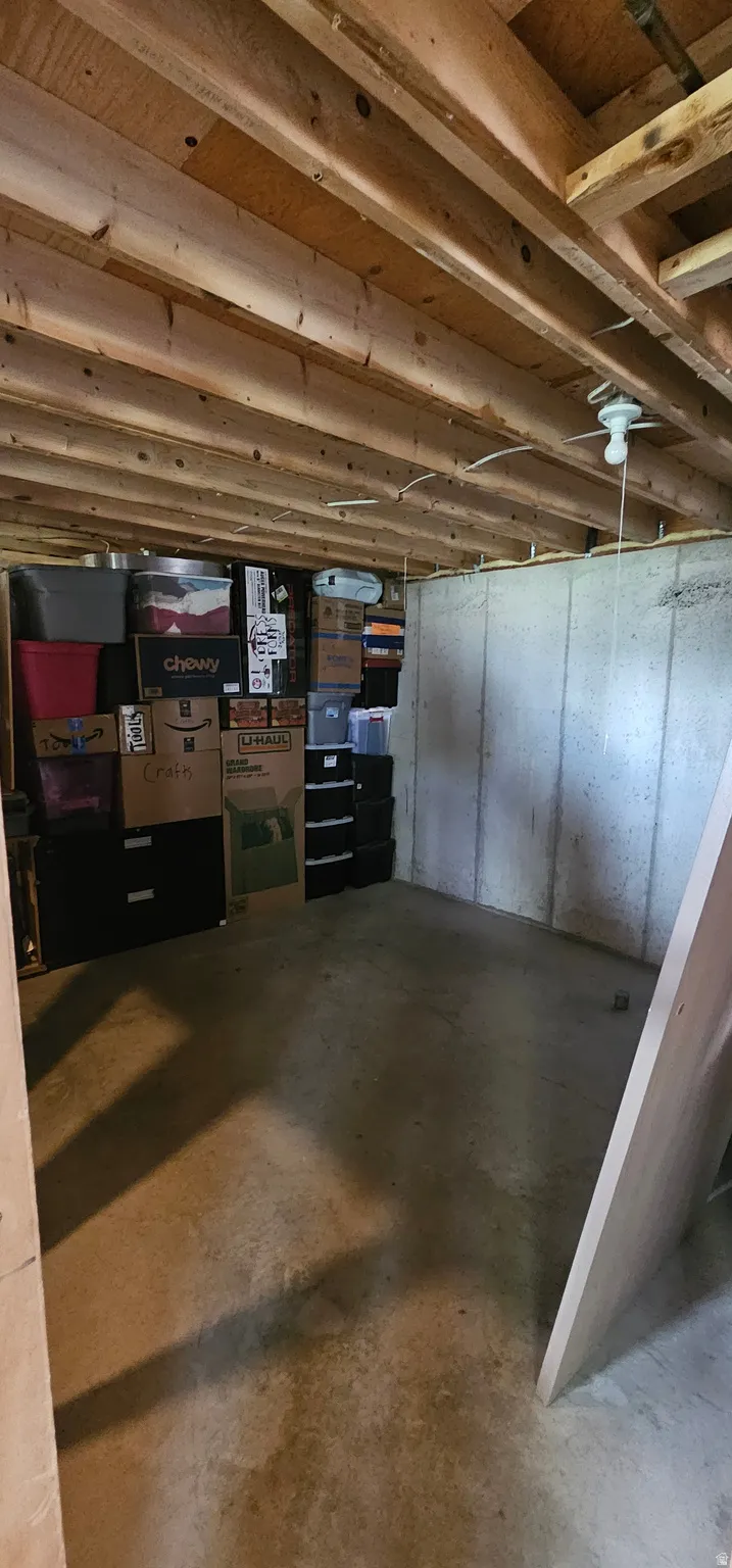 Unfinished basement space featuring exposed wood joists and concrete flooring