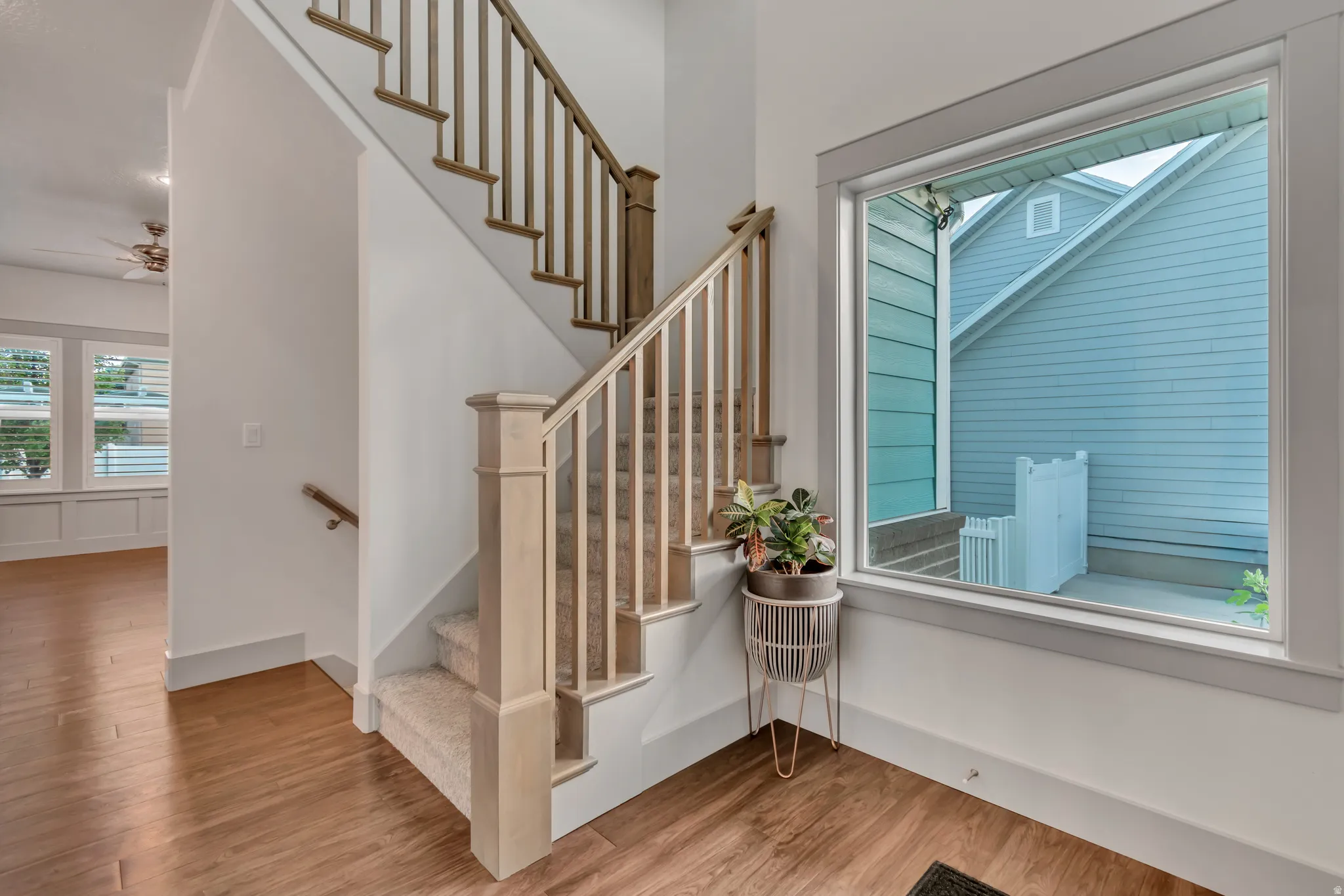 Staircase featuring wood handrails and balusters, carpeted treads, and a prominent newel post