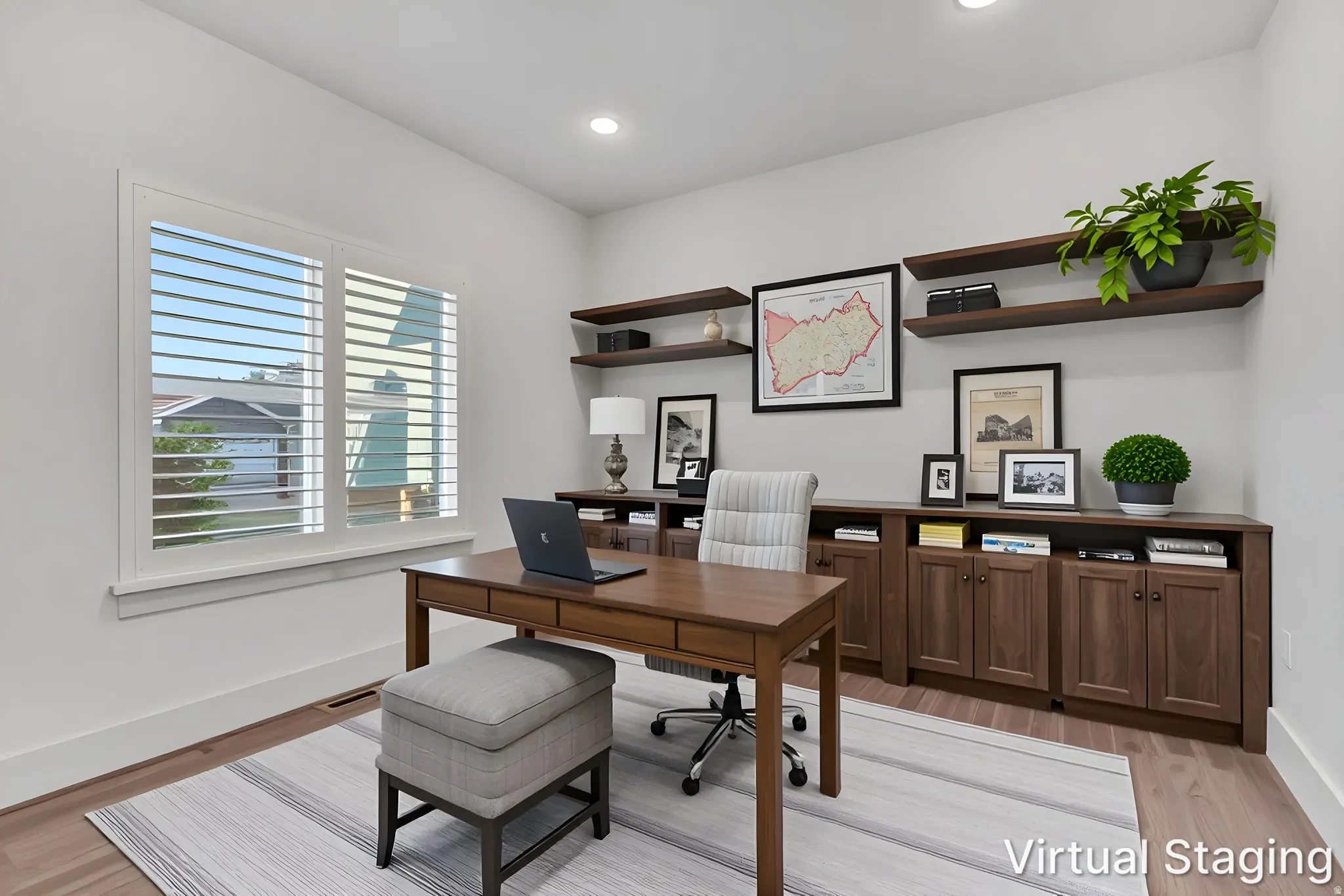 Dedicated office space featuring a large window with plantation shutters, recessed lighting, and wood-finish flooring