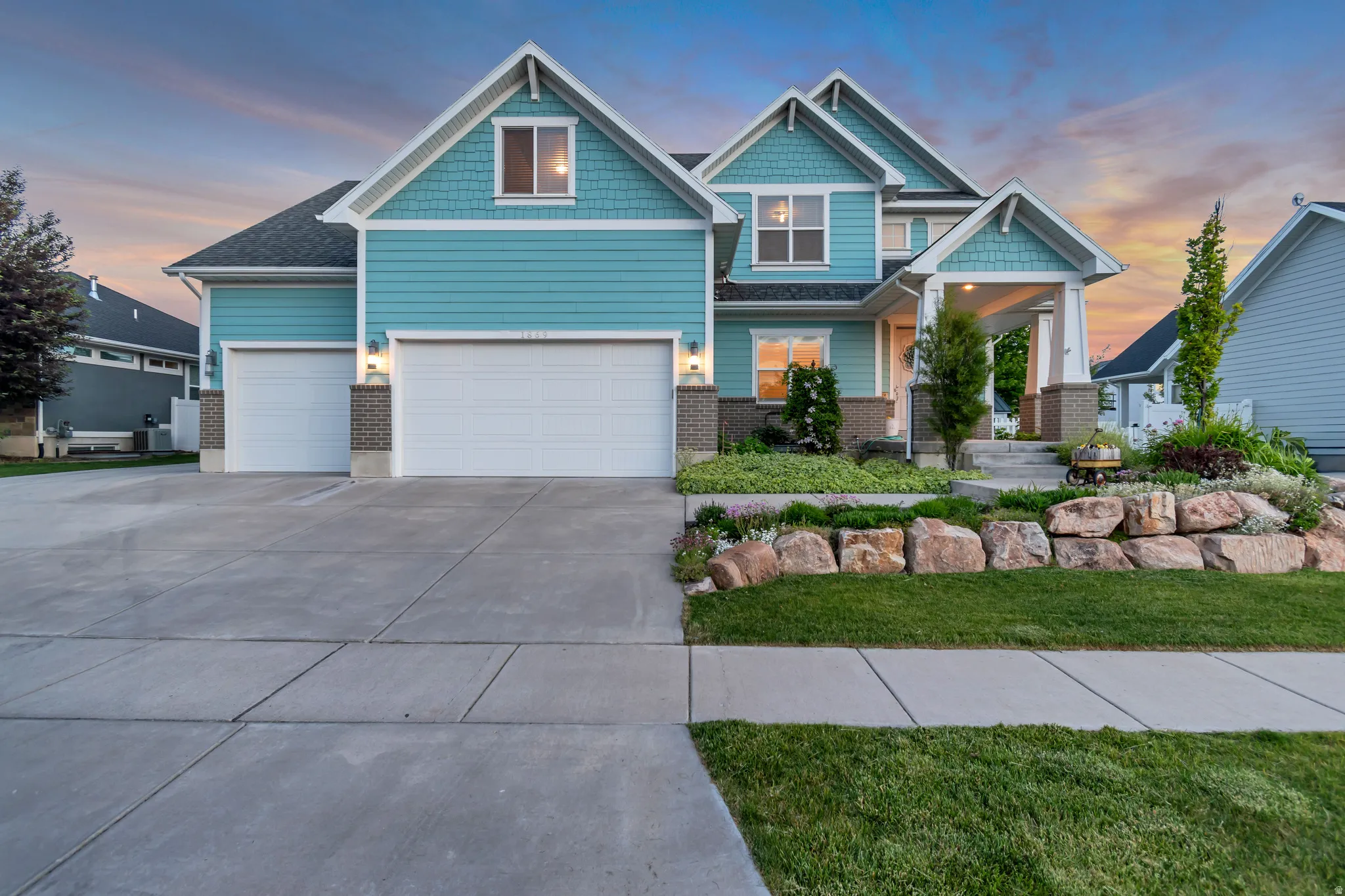 Turquoise siding with white trim accents and a dark roof
