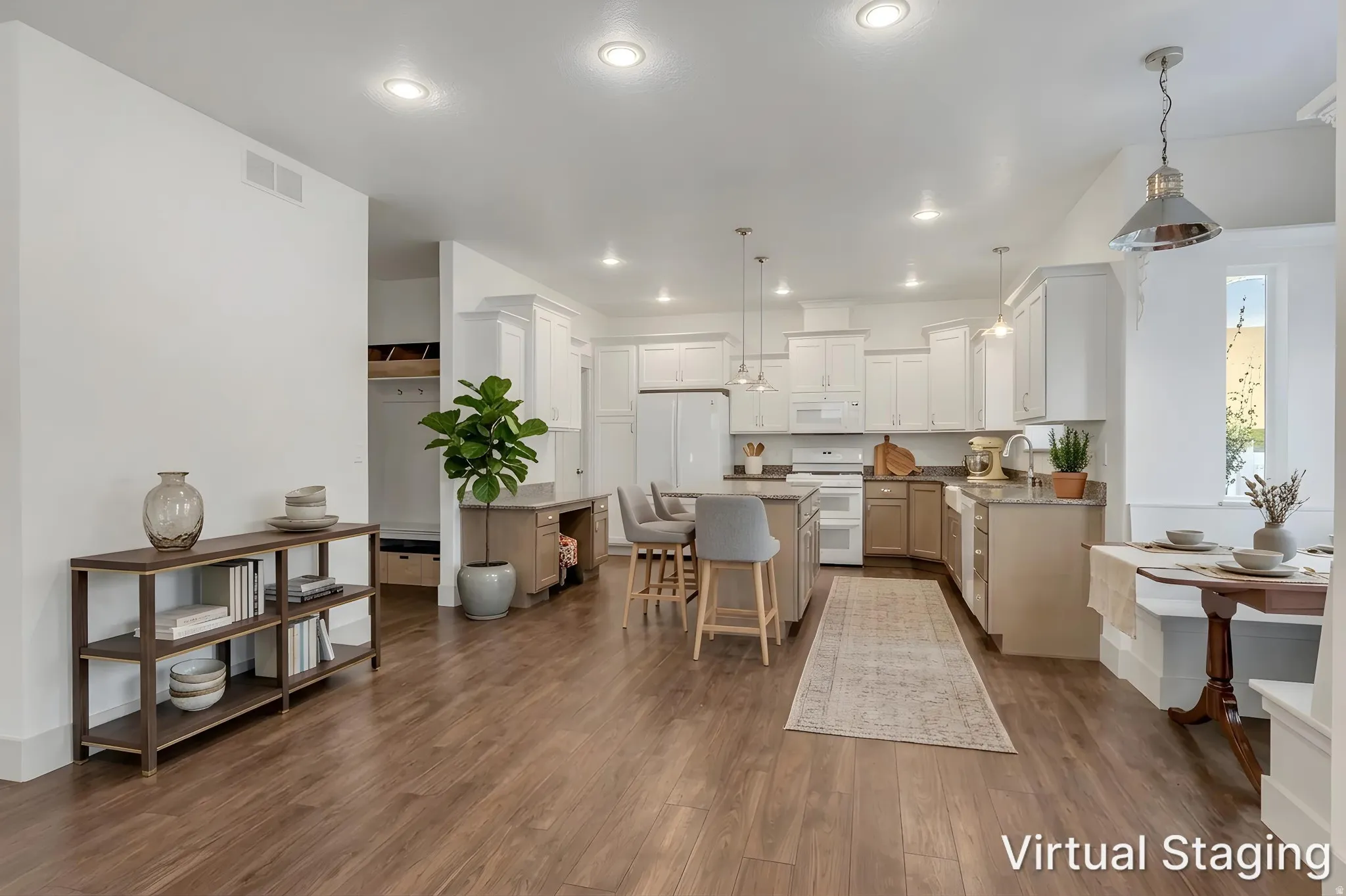 Open-concept living space featuring wood-finish flooring, recessed lighting, and a white kitchen with a center island