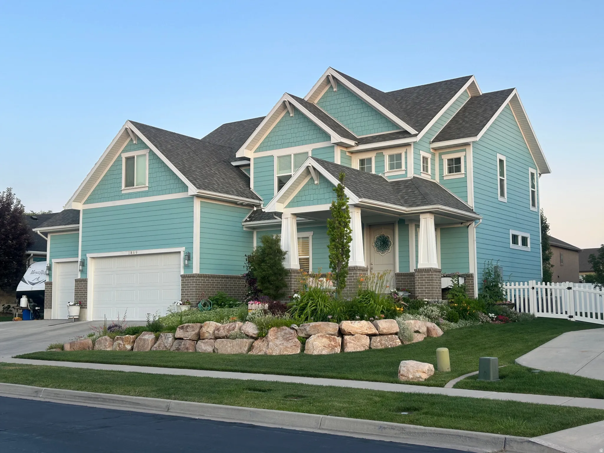 Two-story home featuring light blue siding, white trim, and a dark shingle roof