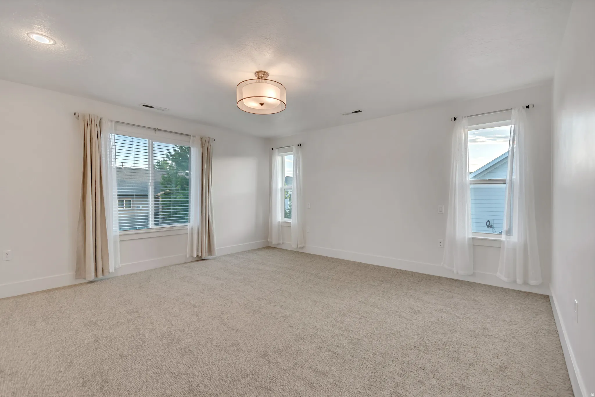 Spacious room featuring neutral carpeting and white walls